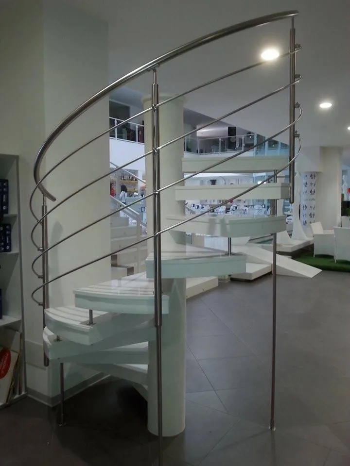 Scala a chiocciola con ringhiera curva in acciaio inox realizzata da Cannata Arredo Inox